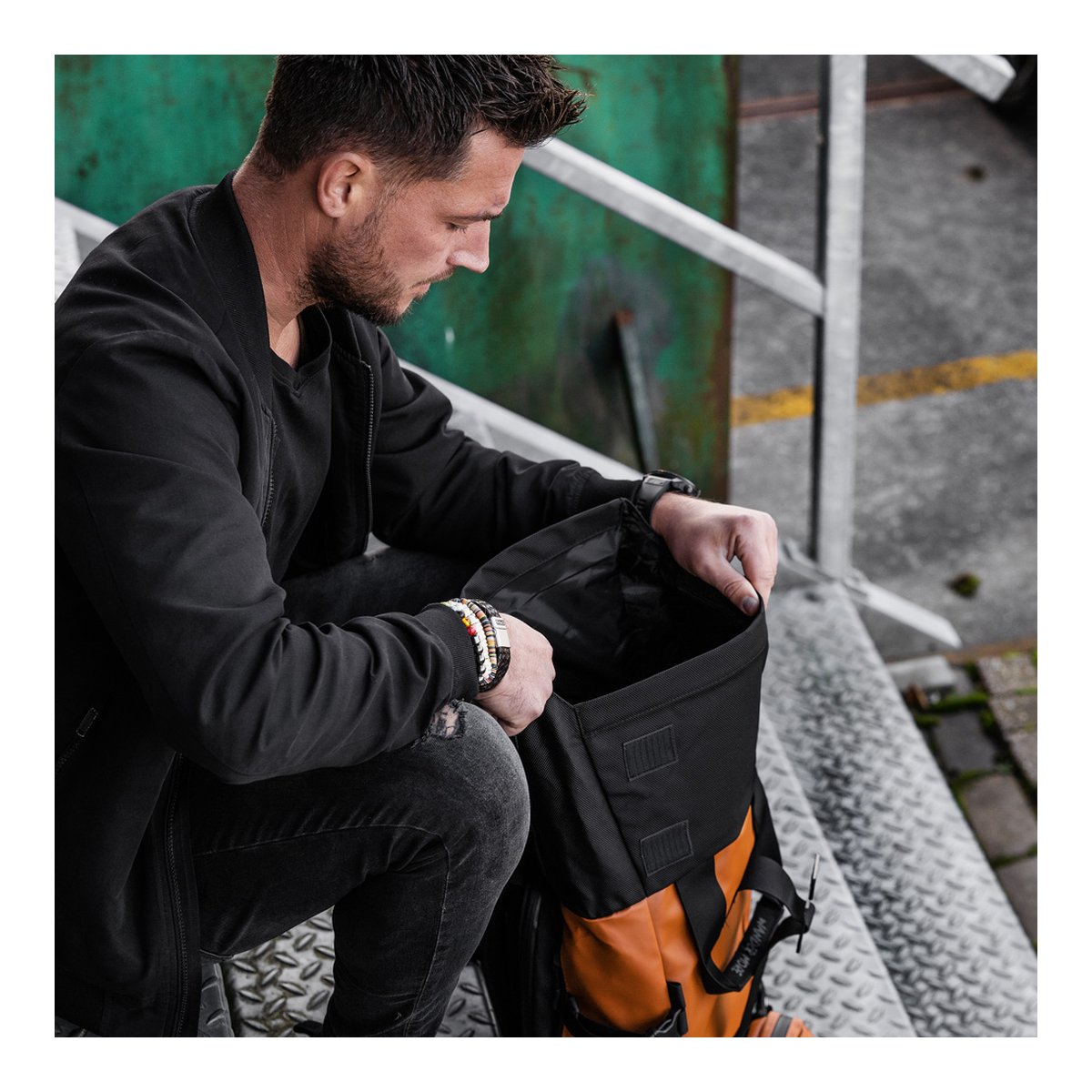 WANDRD PRVKE 21-Liter Sedona Orange Photo Bundle V3 - Anwendungsbeispiel: Mann öffnet Hauptfach des Rucksacks.