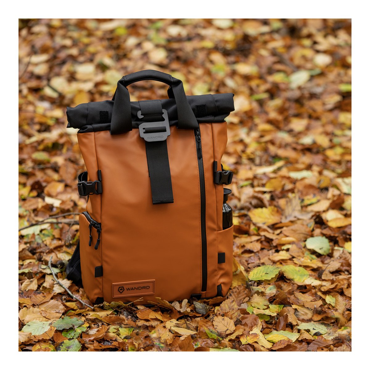 WANDRD PRVKE 21-Liter Sedona Orange Photo Bundle V3 - Anwendungsbeispiel des braunen WANDRD Roll-Top Rucksacks im herbstlichen Wald.