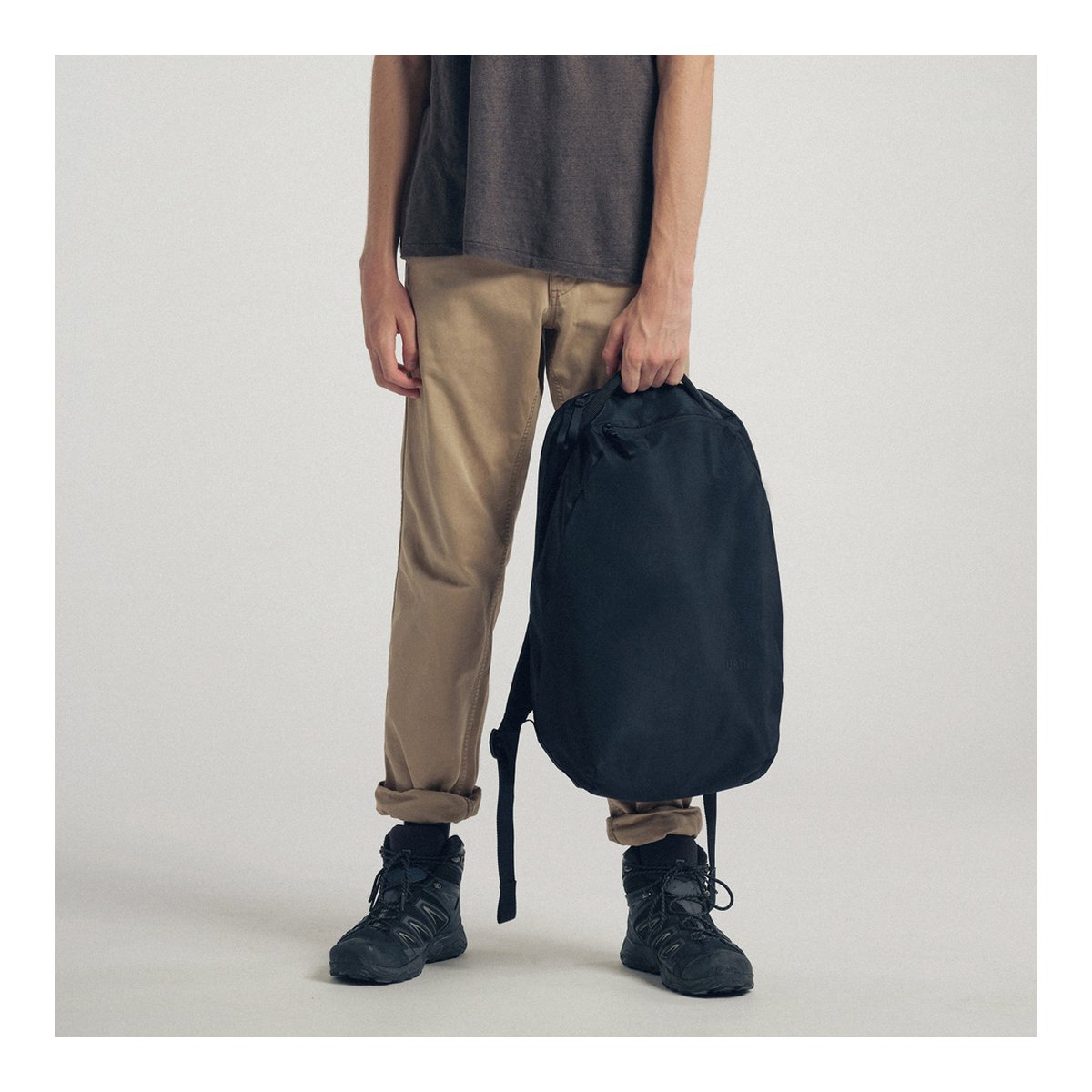 Urth Norite Camera Insert (Schwarz) - Anwendungsbeispiel: Person hält schwarzen Rucksack in der Hand.