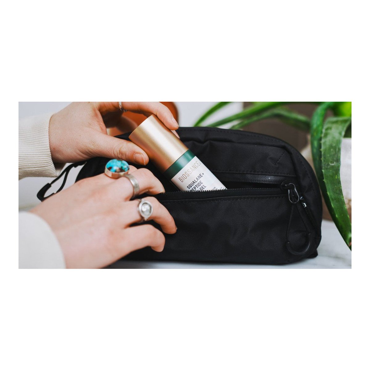 WANDRD Toiletry Bag Medium - Anwendungsbeispiel: Biossance Squalane + Peptide Gel wird in schwarzer Kulturtasche verstaut.